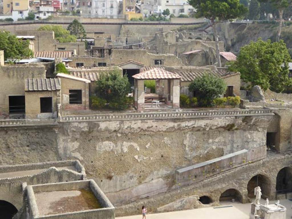 IV.21 Casa dei Cervi or House of the Stags, upper part of photo, October 2014.
Looking north from access roadway to house and terrace, built over the city walls, and having views overlooking sea front.
Photo courtesy of Michael Binns.